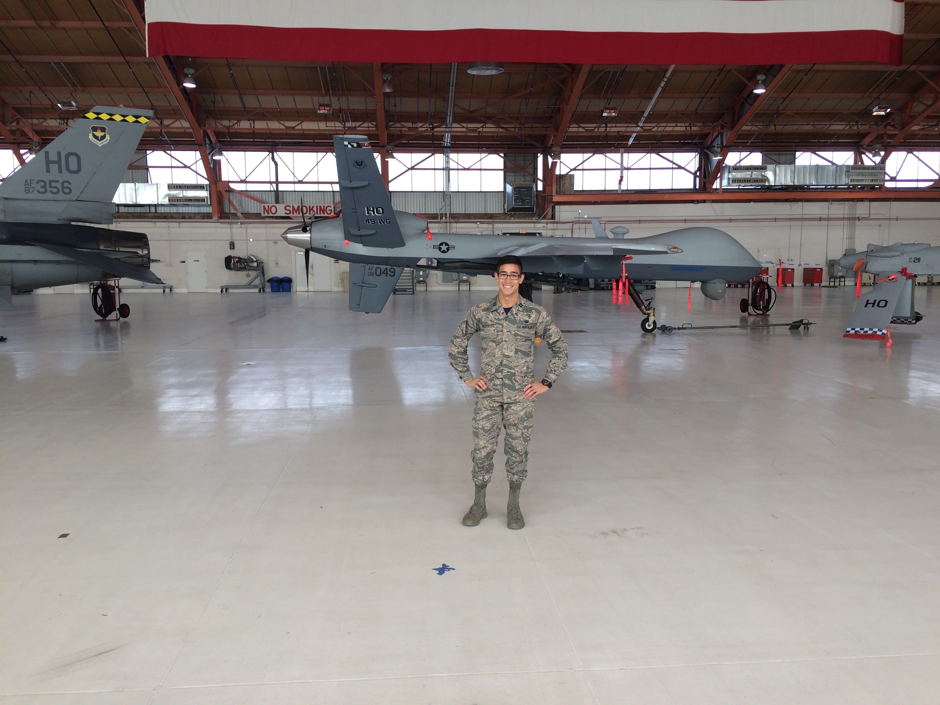 A man in a military uniform standing in a hangar