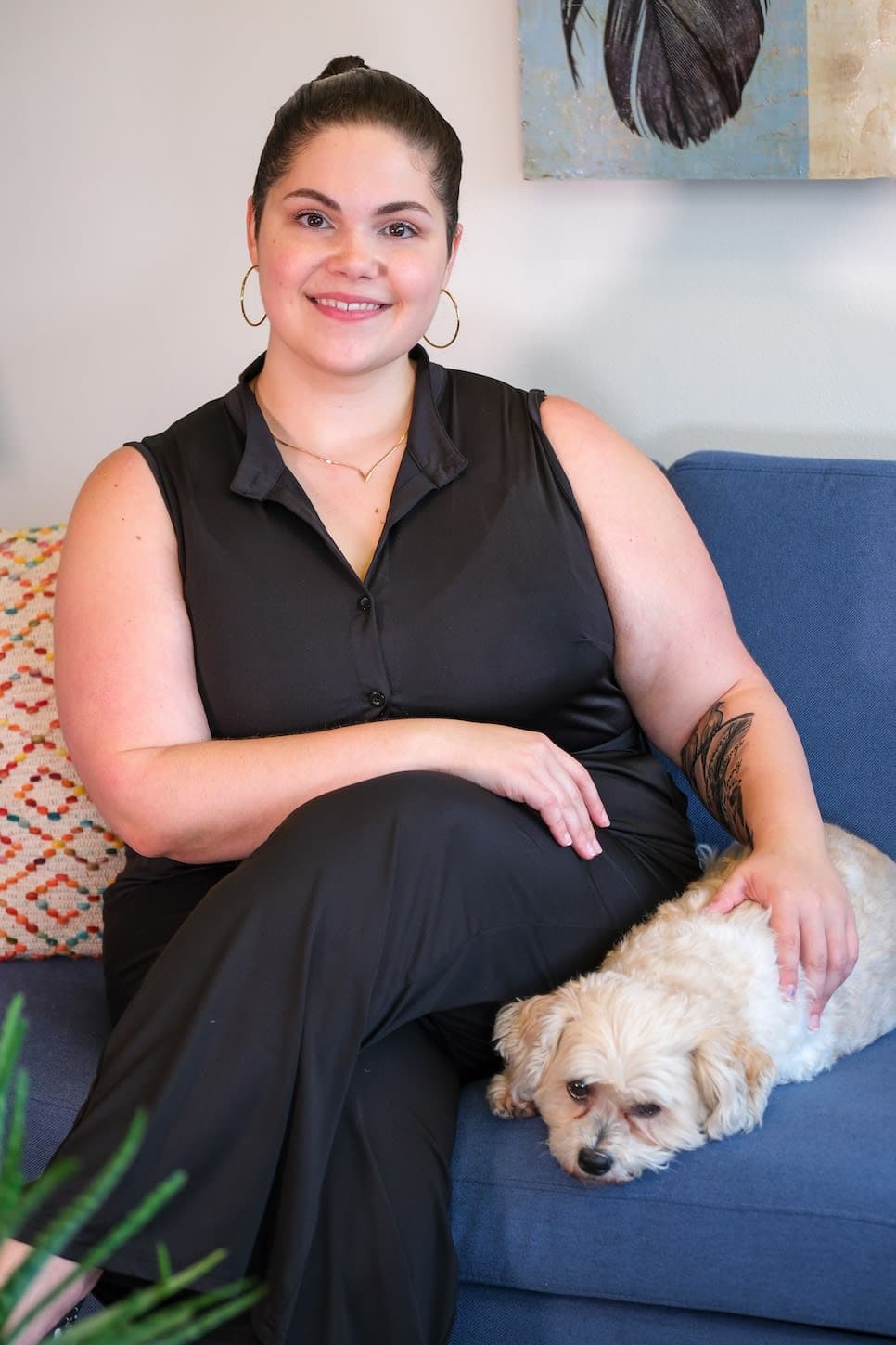 A woman sitting on a couch with a dog