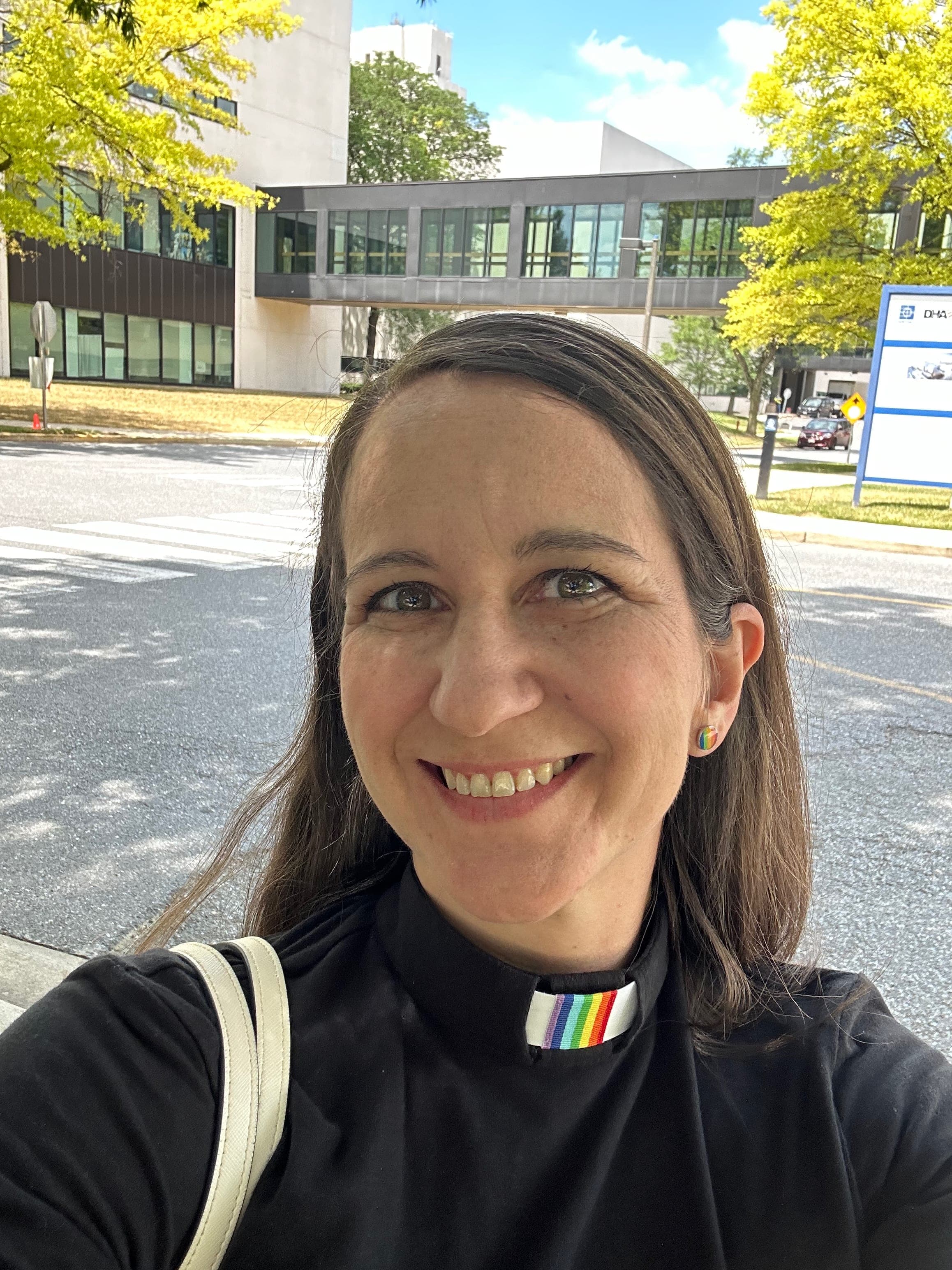 A woman is taking a selfie in front of a building