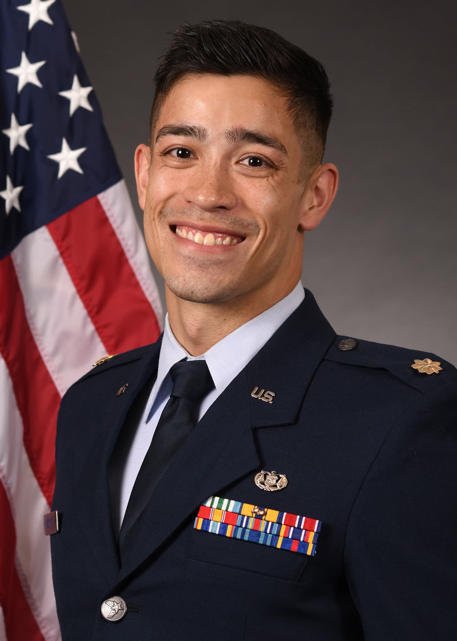 A man in a military uniform in front of an american flag