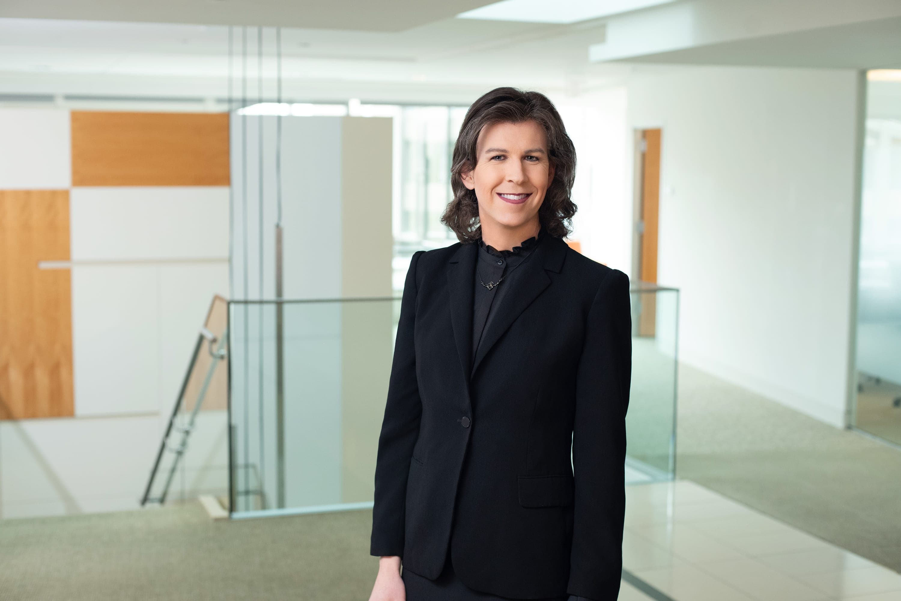 A woman in a black suit standing in a room