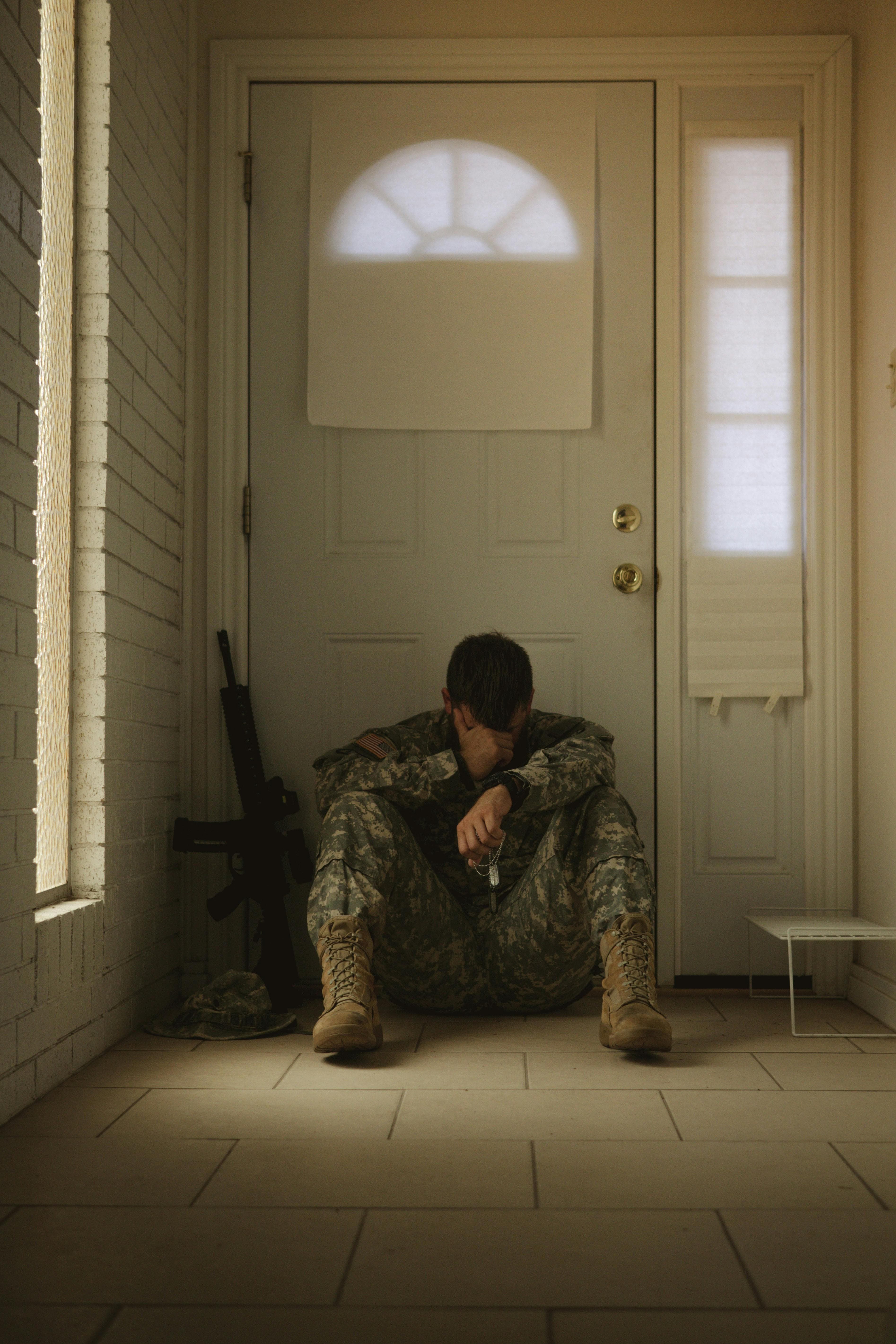 A man sitting on the floor in front of a door