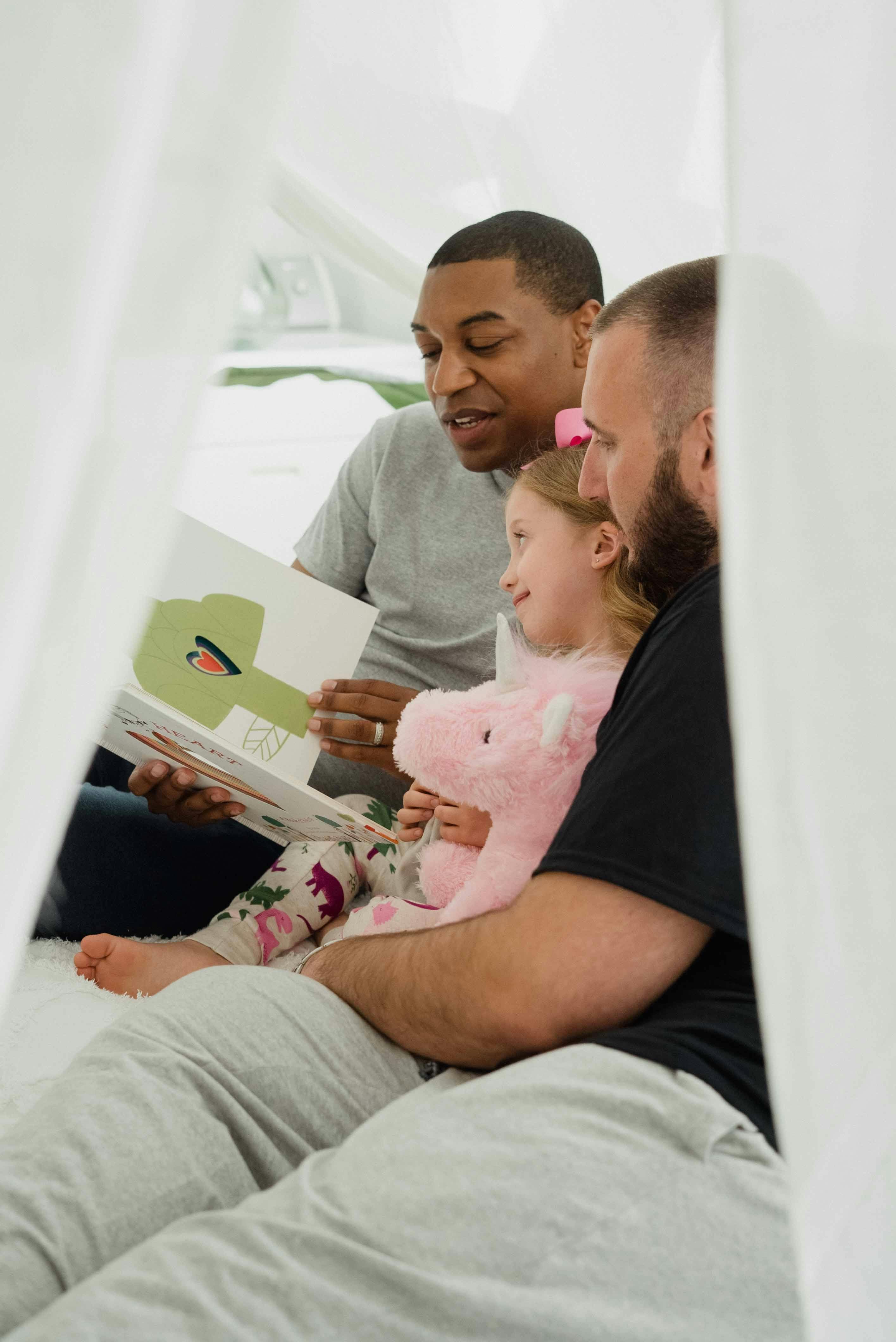 A man reading a book to a little girl